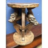 Cameroon style carved stool table, with 4 carved heads below at seat of 30cm diameter. 43cm High.