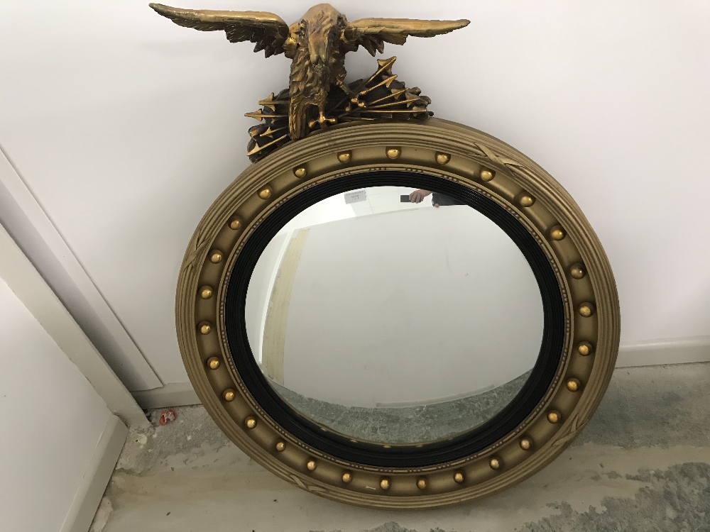 Circular convex Regency gilt mirror with eagle finial 102cm overall height