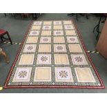 Large Portuguese needlepoint rug, regular square motif on cream & green ground with a red border 200