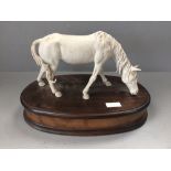 Porcelain horse on wooden plinth