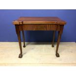 George IV mahogany fold over games table with green baize interior on turned slender legs to pad
