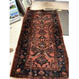 Heavy woollen burgundy ground rug with stylized flora pattern 205 X 106 cm