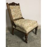 Late Victorian Beech framed fireside chair on turned legs to castors, upholstered in a beige &