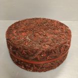 Chinese red cinnabar circular lidded box with carved dragon decoration, the interior of lid &