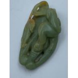 2 Carved Oriental jade pendants, one of a boy with lotus, the other of foliage