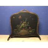 Edwardian fire screen with wooden frame & leather covering, painted with a peacock on a floral
