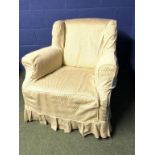 Old traditional winged arm chair with sprung seat in a loose cover