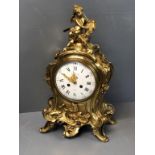 Good French ormolu mantel clock with rococco decoration , white enamel dial beneath a cherub finial.
