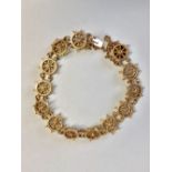 18ct gold nautical bracelet of 13 linked ships wheels by Bernard Taylor & Rebecca retailed by Benzie