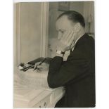 Don Bradman 1953. Original mono press photograph depicting Bradman writing a letter at his desk, the
