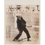 Don Bradman. Reproduction photograph of Bradman batting in later years dressed in a suit. Signed