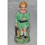Victorian Staffordshire figure of a young child cricketer dressed in a green smock holding a cricket