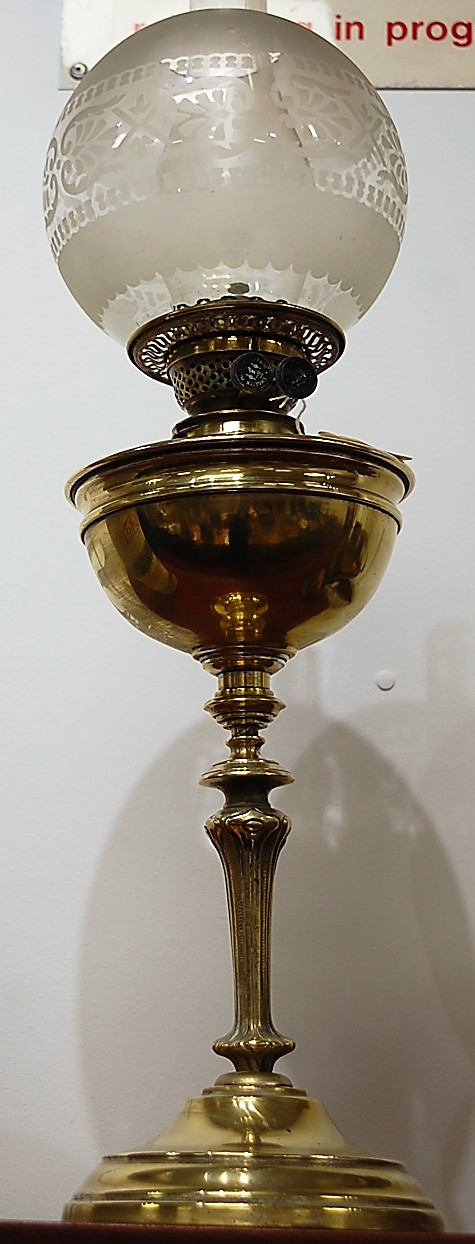 An early 20th century brass pedestal oil lamp, having opalescent globular glass shade