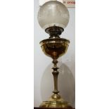An early 20th century brass pedestal oil lamp, having opalescent globular glass shade