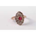 An early 20th century 9ct ruby and diamond ring, the central round ruby in a collet mount, set to