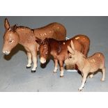 A Beswick donkey, gloss finish, height 13.5cm; and two other smaller examples (3)