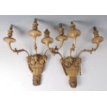 A pair of early 20th century gilt metal and composition three-branch wall lights, with rams head