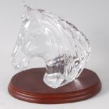 A Waterford clear glass desk ornament in the form of a horse's head, on a wooden plinth, h.14cm.