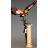A Franklin Mint model of an eagle perched on a branch, on further column base, h.49cm