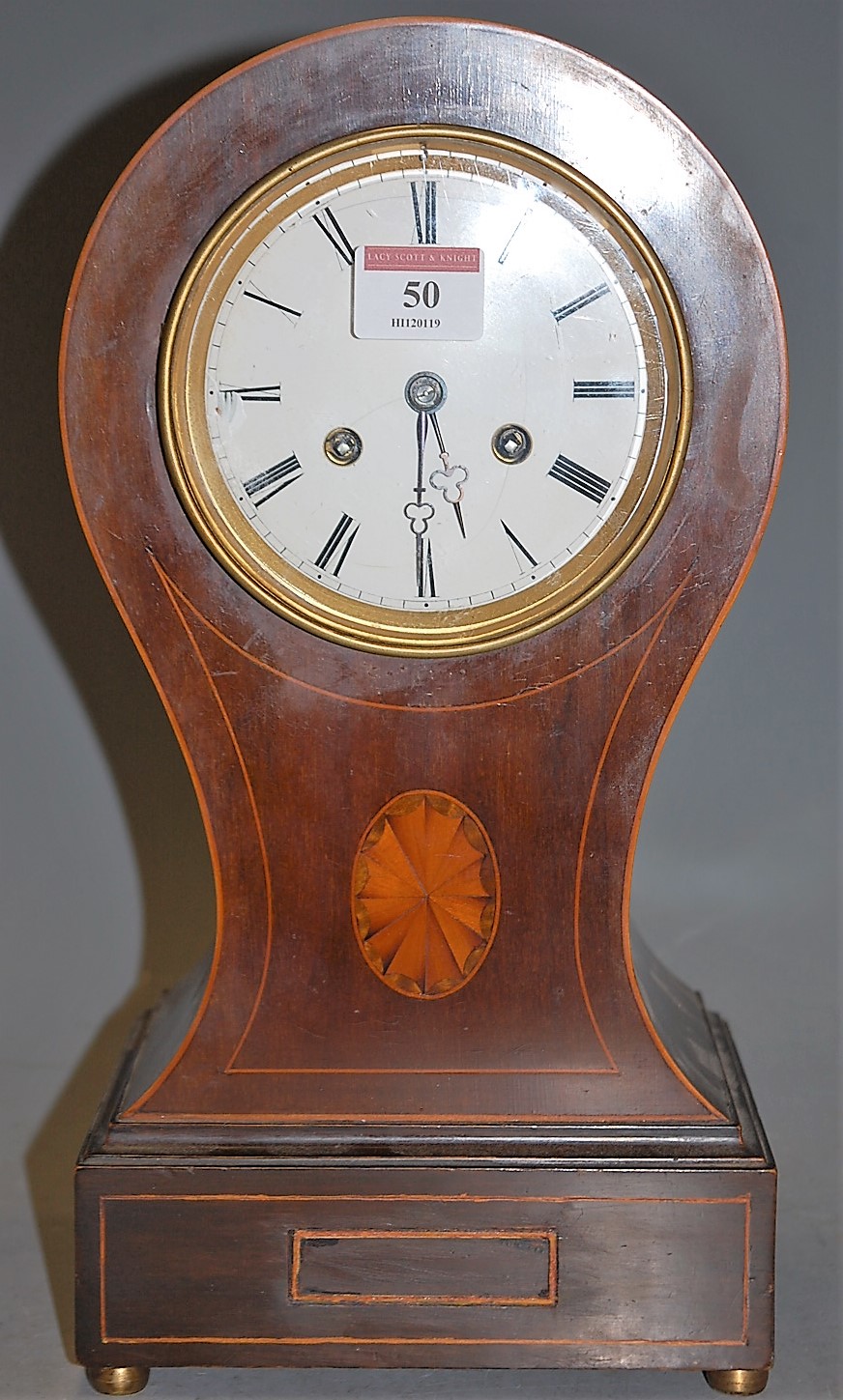 An Edwardian mahogany and satinwood strung balloon shaped mantel clock having an enamel dial with