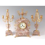 A late Victorian veined rouge marble and gilt metal mounted three piece clock garniture, the clock
