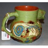 A Devonware art pottery mottoware jug, the body with incised fish decoration, the spout in the