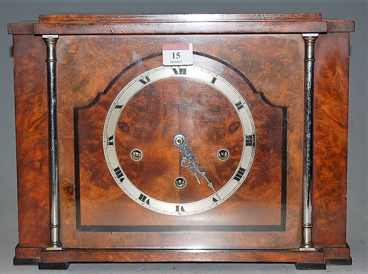 An Art Deco walnut cased mantel clock, having a silvered chapter ring with Roman numerals and