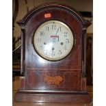 An early 20th century mahogany and satinwood inlaid cased mantel clock of domed form having a