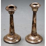 A pair of George V silver table candlesticks (both heavily damaged)