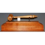 An oversized turned sycamore gavel, raised on an oak plinth, gavel length 32cm