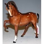 A Beswick model of a horse, having head down and right foot raised, brown gloss finish