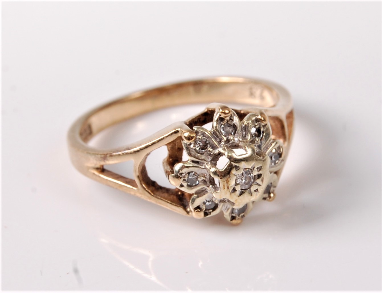 A 9ct gold diamond cluster ring, all illusion mounted with open tapered shoulders and plain band