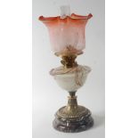 A late Victorian brass pedestal oil lamp, having red tinted acid etched shade, marble glass font,