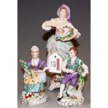 A Rudolf Kammer Volkstedt porcelain figure of a flower seller, height 23cm; together with a pair