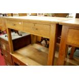 An early 20th century light oak two drawer writing table, w.106cm