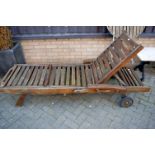 A contemporary stained and slatted teak portable garden lounger