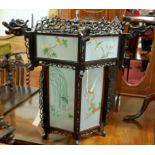 An Oriental pierced and stained wood hexagonal hanging lantern, with painted and frosted inset