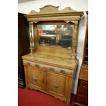 An early 20th century relief carved oak mirror back sideboard