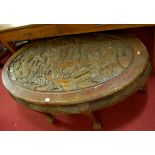 An Indonesian relief carved camphorwood oval coffee table, width 130cm