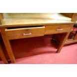 An early 20th century light oak two drawer writing table, w.106cm