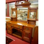 A late Victorian relief carved oak mirrorback sideboard, having three bevelled mirrorplates over