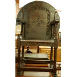 An early 20th century joined and relief carved oak fold-over monks chair, having a circular top