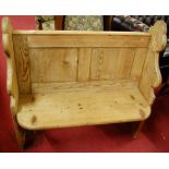 A Victorian pine two seater church pew, having twin recess panelled back, width 100cm