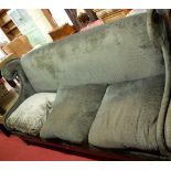 A contemporary upholstered and studded four seater wingback sofa raised on tapering supports,