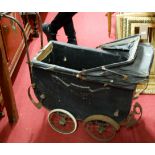 A vintage black painted wooden dolls pram