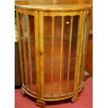 A 1930s figured walnut demi-lune single door glazed china display cabinet, w.91cm