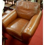 A contemporary tan leather upholstered club armchair, together with matching footstool (2)