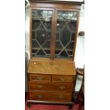 An Edwardian mahogany and satinwood crossbanded bureau bookcase, having twin astragal glazed upper