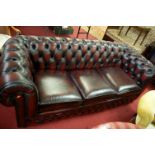 A contemporary oxblood red leather button back three seater Chesterfield sofa bed, width 200cm