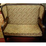 An oak floral upholstered and further studded winged two seater pub settle, width 122cm